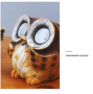 Detailed view of solar owl garden light with LED eyes and rustic faux wood texture