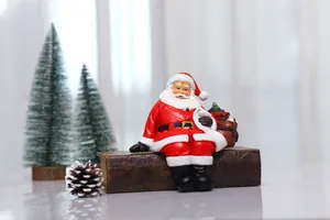 Close-up of sitting Santa Claus resin ornament with red gift bag on vintage books