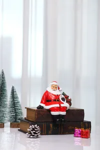 Detailed view of a Santa Claus figurine holding a gift bag on vintage books decoration