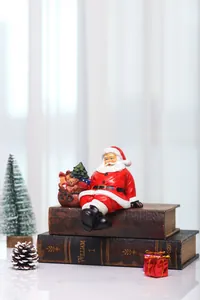 Close-up of resin Santa Claus figurine with gift sack and miniature Christmas tree decor
