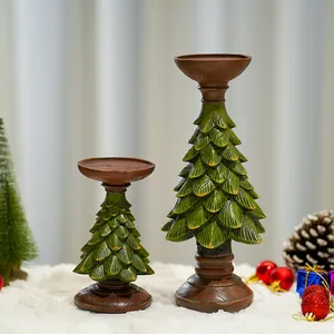 Paire de bougeoirs sapin de Noël en résine verte avec base en bois sur neige blanche