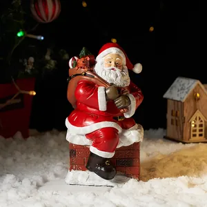 Statuina di Babbo Natale in resina su un camino con sacco di regali per decoro da tavolo