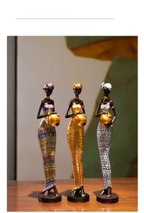 Detailed close-up of exotic black women resin figurines with gold accessories and jars