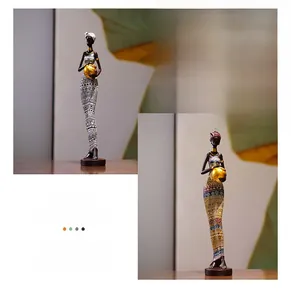 Detail of African resin statues with gold bowls and colorful ethnic patterns