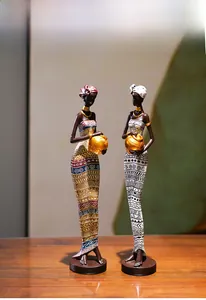 Detailed view of hand-painted African resin figurines with golden necklaces and tribal dresses