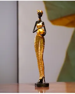 Detail of creative African resin figurine with gold tribal patterns on a black base