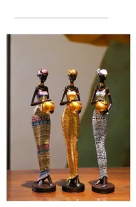 Détail de trois statues de femmes africaines tribales en résine avec parure dorée