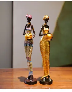 Detail of African resin statues with golden jewelry and colorful geometric patterns