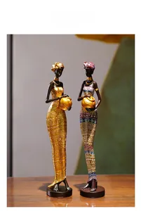Détail de deux figurines de femmes tribales africaines avec accents dorés et motifs ethniques
