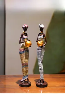 Détail de statues de femmes africaines en résine avec motifs tribaux et colliers dorés