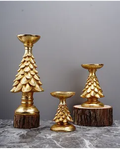 Detailed view of three golden Christmas tree candle holders with textured metallic finish