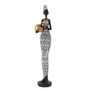 Figurine de femme africaine avec robe géométrique noir et blanc tenant un pot doré