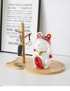 Detail of wooden key organizer stand with lucky cat ornament and tray for jewelry