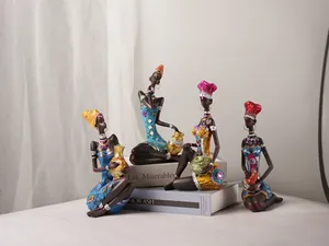 Detailed view of four colorful resin African figurines set on books for home decoration
