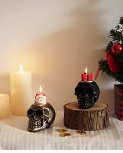 Detail van bronzen en zwarte schedel kandelaars met feestelijke Kerstman en cadeau kaarsen