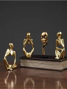 Set of four gold abstract thinker sculptures with a matte resin finish for home decor