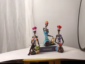 Detailed view of three resin African tribal women figurines with colorful glitter and rhinestones
