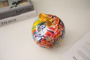 Detalle de estatua de manzana graffiti con hoja dorada y motivos de arte callejero