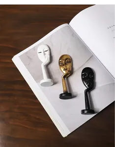 Detailansicht von drei abstrakten Maskenskulpturen in Weiß, Gold und Schwarz aus Harz