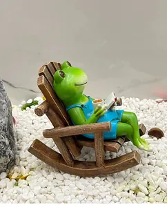 Figurine de grenouille en résine avec tasse de café et livre sur une chaise à bascule