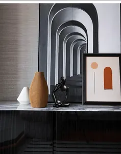 Detailed view of abstract face sculpture and textured vases on a modern black marble table