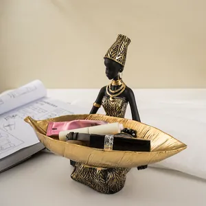 Λεπτομέρεια αφρικανικής φιγούρας με χρυσό δίσκο φύλλων για οικιακή αποθήκευση