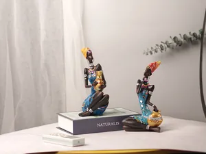 Detail of African tribal figurines with blue dresses and mirrored tile accents on a table