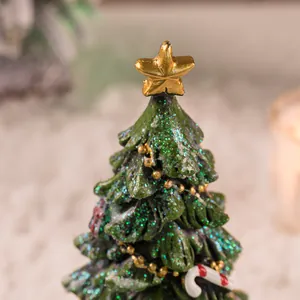 Detail van een mini hars kerstboom met gouden ster en rood-witte zuurstokjes