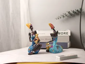 Close-up of African resin figurines with vibrant blue dresses and gold detail craftsmanship