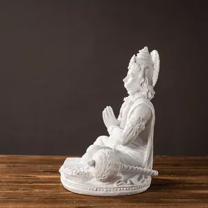 Macro detail of Hanuman resin statue with prayer pose and gada on dark background