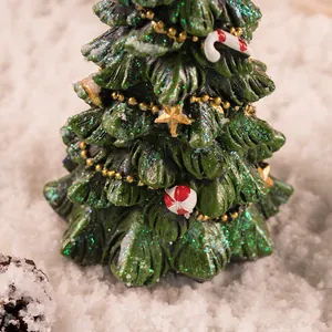 Detailopname van een kunsthars kerstboom met glitters, gouden kralen en snoepornamenten