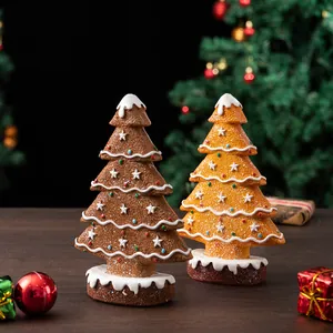 Macro detail of gingerbread Christmas tree resin ornaments with snow icing and star topper