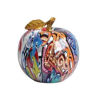 Escultura de manzana graffiti con vibrantes patrones de street art y detalle de tallo dorado