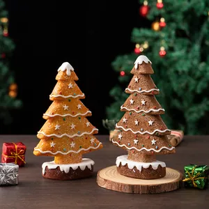Gingerbread Christmas tree resin ornaments with cream texture on dark wood table