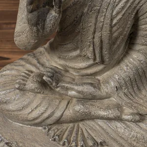 Macro detail of Zen Buddha statue hands showing stone texture and antique grey finish