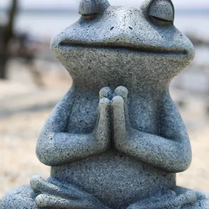 Macro detail of a meditating frog statue with realistic stone texture and zen pose