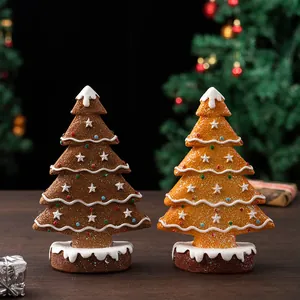 Detail of gingerbread resin Christmas trees with frosting decor and glitter on wood base
