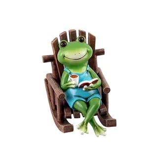 Figurine de grenouille rigolote en résine lisant sur une chaise à bascule décorative