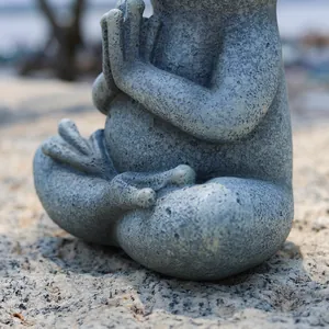Close-up of a meditating resin frog statue with a natural grey stone texture for garden decor