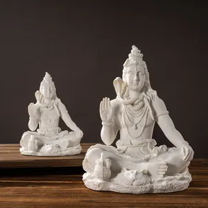 Detailed view of two white resin Shiva Hindu god statues in sitting pose on wood