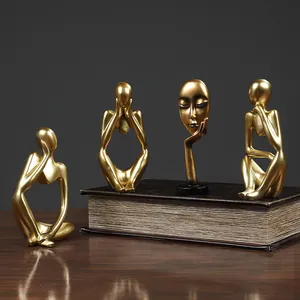 Golden Nordic abstract mask thinker statues on vintage books for desktop decor