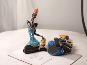 Macro detail of African resin figurines featuring blue jeweled dresses and gold accents