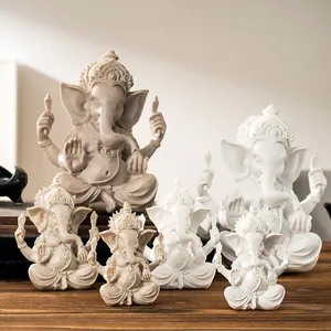 Detailed view of Ganesha resin statues in beige and white finishes with ornate textures