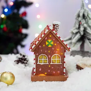 Lighted Christmas gingerbread house resin ornament with red candy stripes and festive snow