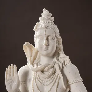 Macro shot of white Shiva statue detailing the Om symbol and intricate resin carvings