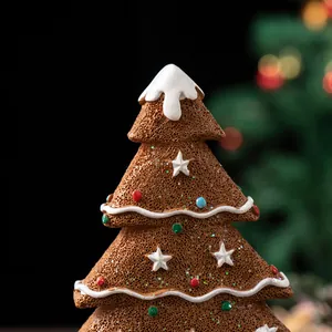 Macro detail of gingerbread Christmas tree resin ornament with snowy texture and colorful dots