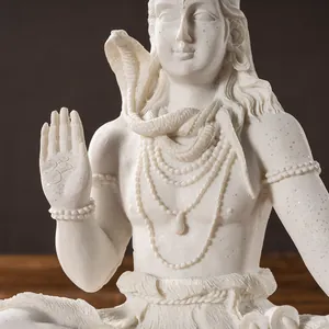 Detailed close-up of white resin Shiva statue with Om symbol and cobra engraving