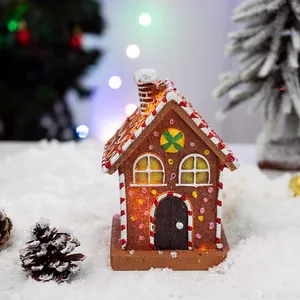 Lighted Christmas gingerbread house resin decoration with faux snow and pine cones