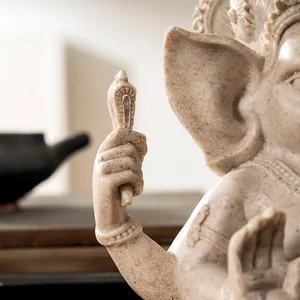 Macro detail of sandstone Ganesha statue hand holding a symbolic ritual object