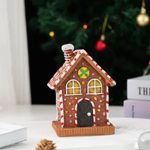 Detail view of a gingerbread house resin ornament with icing sugar and candy decorations